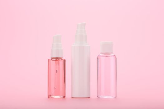 Cleaning foam, face cream and skin lotion against pink background. Concept of daily skin care or anti aging treatment