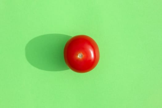 tomato with a hard shadow on a colored background pattern. High quality photo