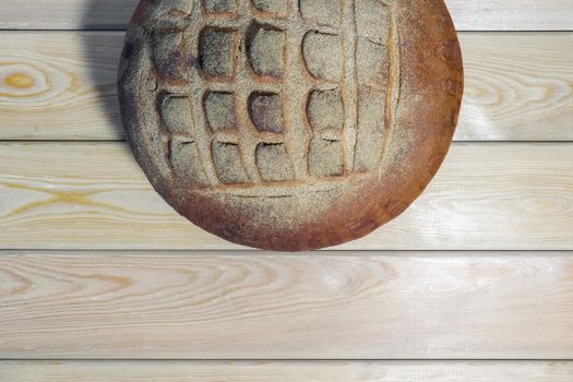 a loaf of bread on a wooden background. High quality photo