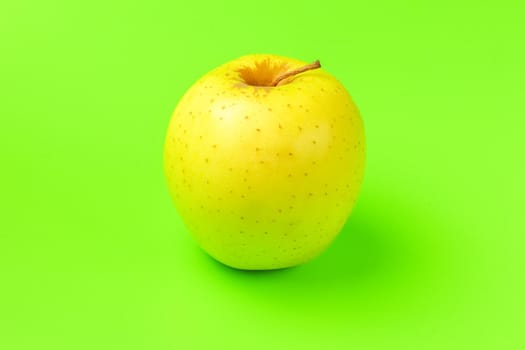 yellow Apple on a green background close-up.isolate. High quality photo