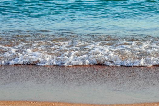 Soft Wave Of Blue Ocean On Sandy Beach. Background. Selective focus. High quality photo