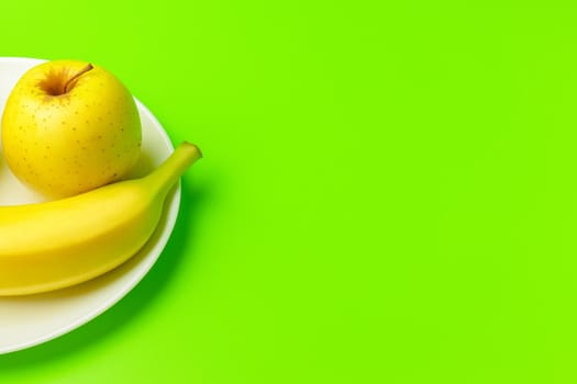 banana and Apple on a green background close-up. isolate. High quality photo