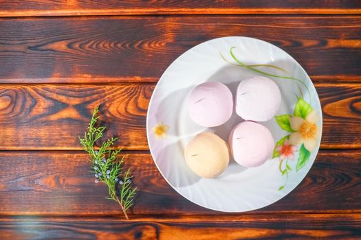 colorful marshmallows on a plate on a wooden background. High quality photo