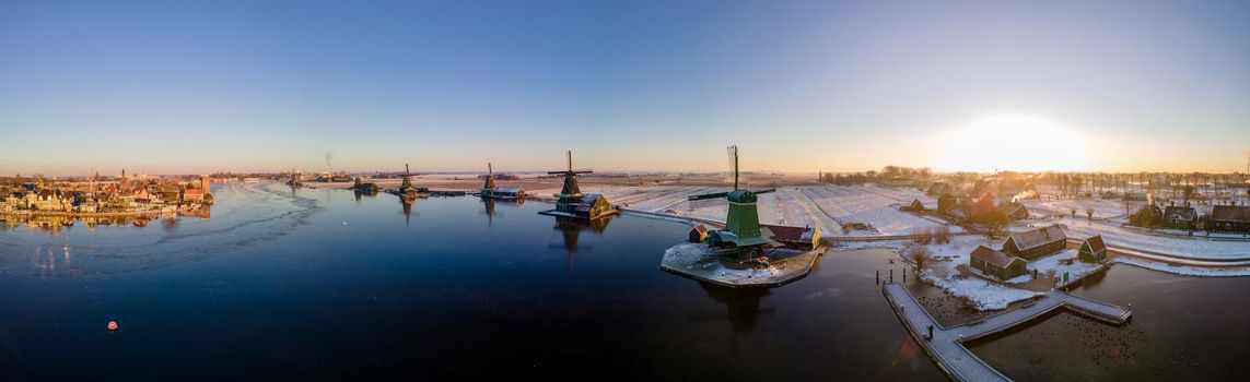 panoramic view over the Zaanse Schans windmill village snow covered during winter, Zaanse Schans wind mills historical wooden mills in the Netherlands. Europe
