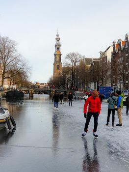 Amsterdam Netherlands, frozen canals and people ice skating in Amsterdam Netherlands february 2021