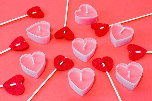 pink candles in the form of a heart on a red background for Valentine's day . High quality photo