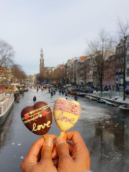 love romantic ice cream with on the background people ice skating at the frozen canals of Amsterdam, Valentine Romantic concept. Amsterdam Netherlands