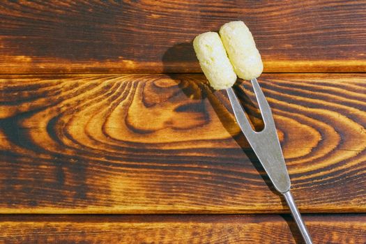 corn sticks on a fork on a wooden background. High quality photo