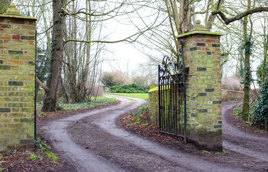 Old open Gate of Country Estate with iron antique gate. Road leading to estate, park, property