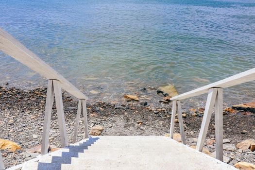 white staircase on the beach leading to the sea. High quality photo