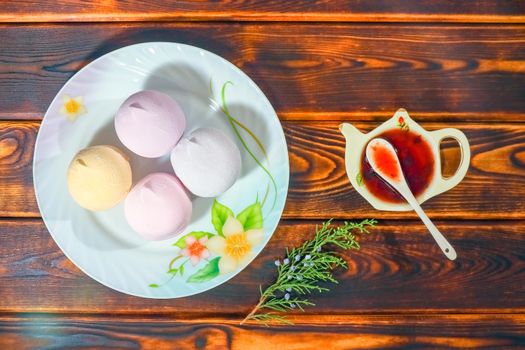 colorful marshmallows on a plate on a wooden background. High quality photo