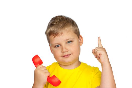 A boy in a yellow T-shirt on a white background with a red telephone receiver. Indicates to call here. The concept of a banner with information. Space for the text. Concepts