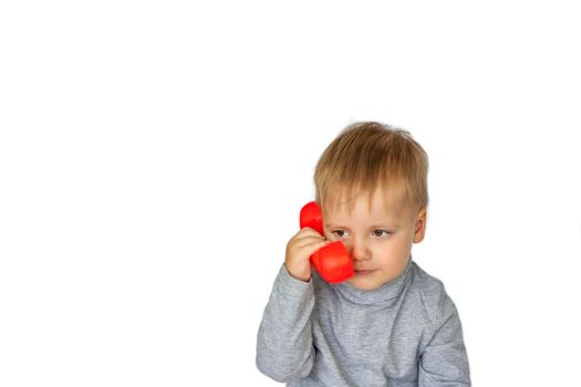 A boy in a gray sweatshirt on a white background with a red telephone receiver. Indicates to call here. The concept of a banner with information. Space for the text. Concepts