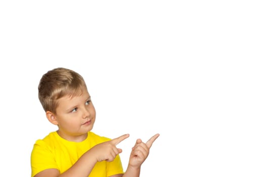 A boy in a yellow T-shirt on a white background points his fingers at something. The concept of a banner with information. Space for the text. Concepts 