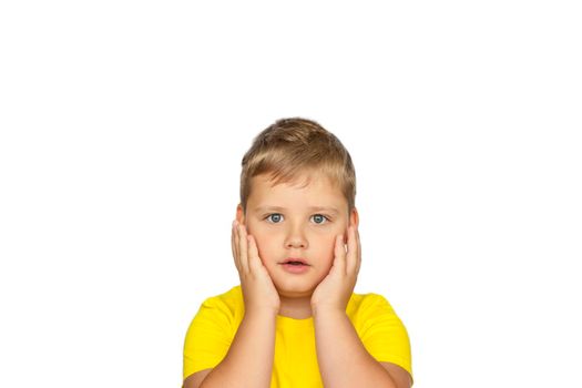 A boy in a yellow T-shirt on a white background experiences an emotion of surprise. The concept of a banner with information. Space for the text. Concepts 