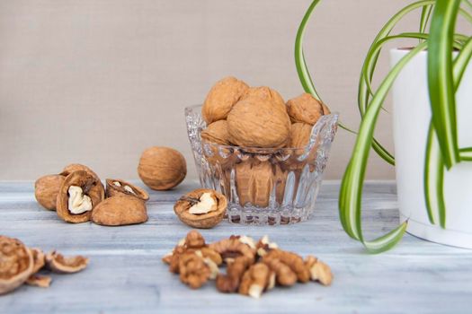 Walnuts on a painted background. Crystal bowl with nuts. Useful products. Walnuts.   