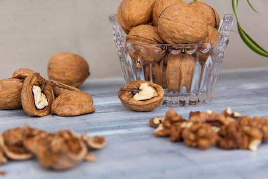 Walnuts on a painted background. Crystal bowl with nuts. Useful products. Walnuts. 