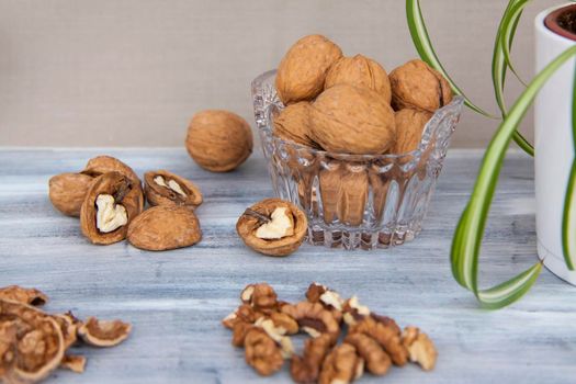 Walnuts on a painted background. Crystal bowl with nuts. Useful products. Walnuts.