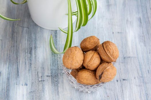 Walnuts on a painted background. Crystal bowl with nuts. Useful products. Walnuts.