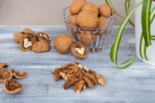 Walnuts on a painted background. Crystal bowl with nuts. Useful products. Walnuts.