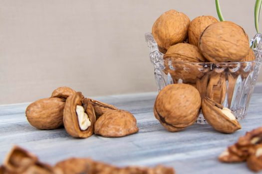 Walnuts on a painted background. Crystal bowl with nuts. Useful products. Walnuts.