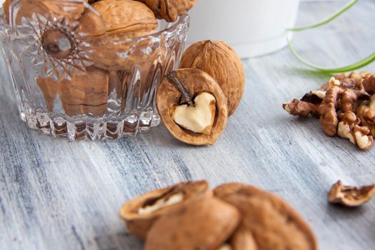 Walnuts on a painted background. Crystal bowl with nuts. Useful products. Walnuts.