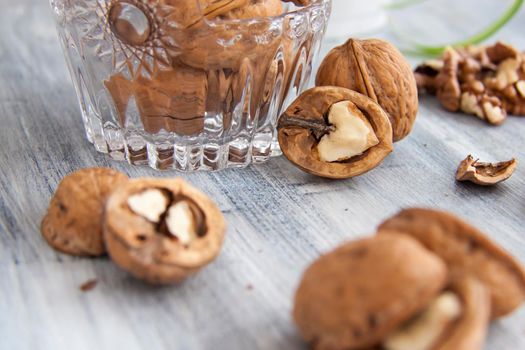 Walnuts on a painted background. Crystal bowl with nuts. Useful products. Walnuts.