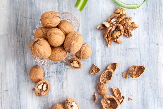 Walnuts on a painted background. Crystal bowl with nuts. Useful products. Walnuts.