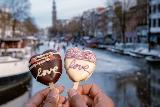 love romantic ice cream with on the background people ice skating at the frozen canals of Amsterdam, Valentine Romantic concept. Amsterdam Netherlands