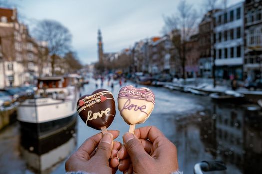 love romantic ice cream with on the background people ice skating at the frozen canals of Amsterdam, Valentine Romantic concept. Amsterdam Netherlands