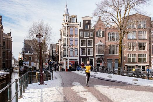 Amsterdam during winter with snowy streets. Amsterdam Netherlands February 2021