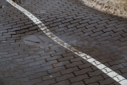 pit defect on modern sidewalk gray concrete brick pavement with white line for bicycle path separation