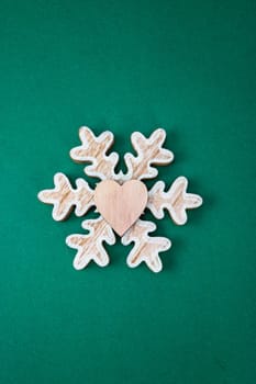 Snowflake Christmas decoration on green background. Top view with copy space for december season.