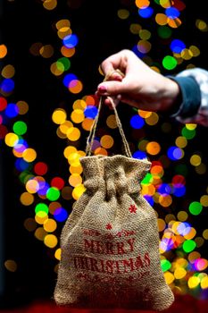 Woman's hands hold christmas decoration. Christmas and New Year holidays background, winter season with Christmas ornaments and blurred lights