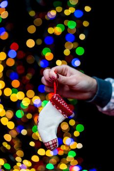 Woman's hands hold christmas decoration. Christmas and New Year holidays background, winter season with Christmas ornaments and blurred lights