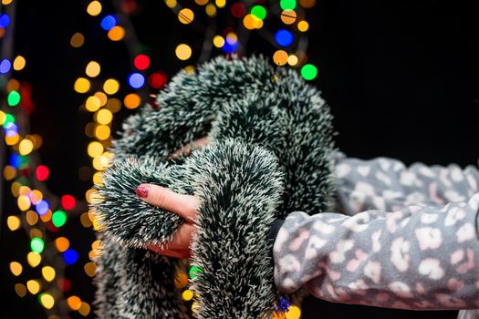 Woman's hands hold christmas decoration. Christmas and New Year holidays background, winter season with Christmas ornaments and blurred lights