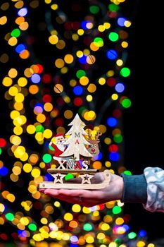 Woman's hands hold christmas decoration. Christmas and New Year holidays background, winter season with Christmas ornaments and blurred lights