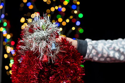 Woman's hands hold christmas decoration. Christmas and New Year holidays background, winter season with Christmas ornaments and blurred lights