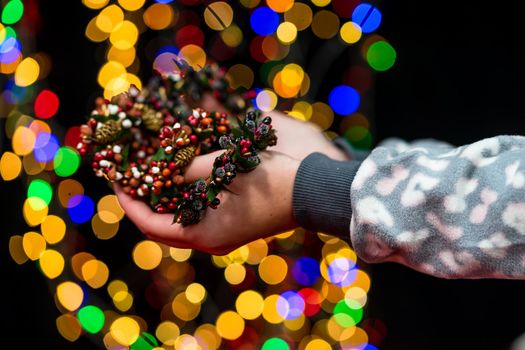 Woman's hands hold christmas decoration. Christmas and New Year holidays background, winter season with Christmas ornaments and blurred lights