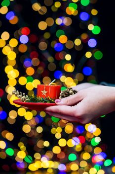 Woman's hands hold christmas decoration. Christmas and New Year holidays background, winter season with Christmas ornaments and blurred lights