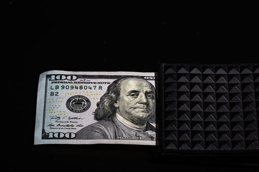 100 Dollars banknotes in a black wallet isolated