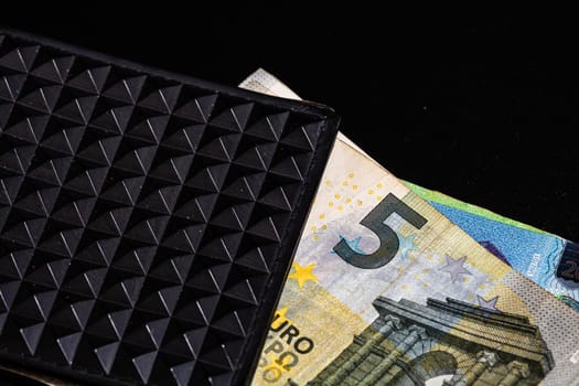 5 Euro money banknotes in black wallet isolated