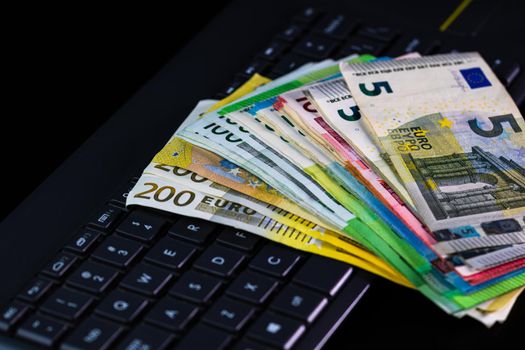 Euro  banknotes on keyboard. Selective focus on stack euro money.