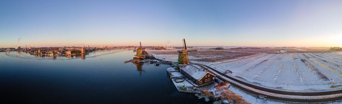 panoramic view over the Zaanse Schans windmill village snow covered during winter, Zaanse Schans wind mills historical wooden mills in the Netherlands. Europe