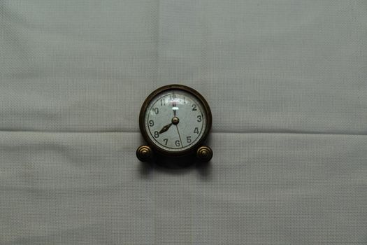 Centered vintage clock with white fabric backing