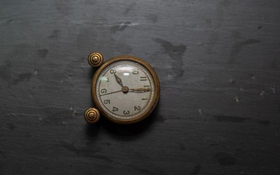 Vintage clock on a black slate background