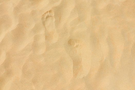 footprints on the beach dune sand as a background. High quality photo