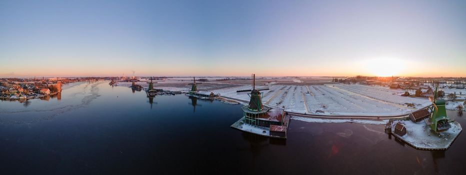 panoramic view over the Zaanse Schans windmill village snow covered during winter, Zaanse Schans wind mills historical wooden mills in the Netherlands. Europe
