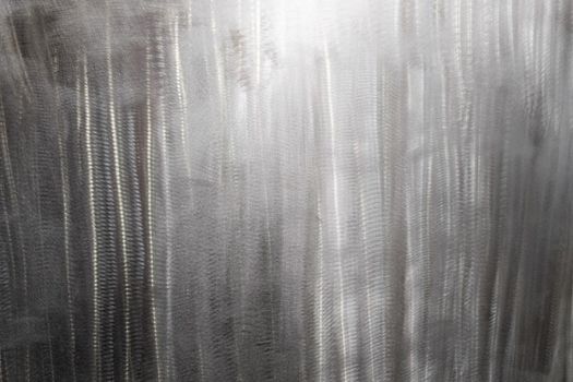 Close-up texture of flat steel surface manually cleaned with a flap wheel angle grinder. Surface prepaired before painting as part of the repair work.