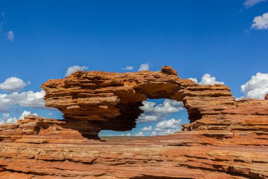 Nature's Window, a natural arch rock formation in Kalbarri National Park on a sunny day with white clouds